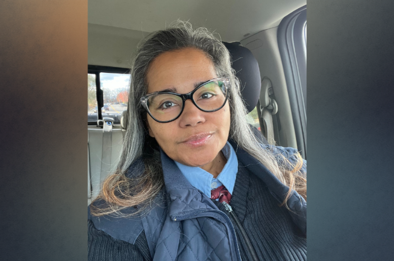 Ruth Rodriguez sits in a vehicle and smiles at the camera.