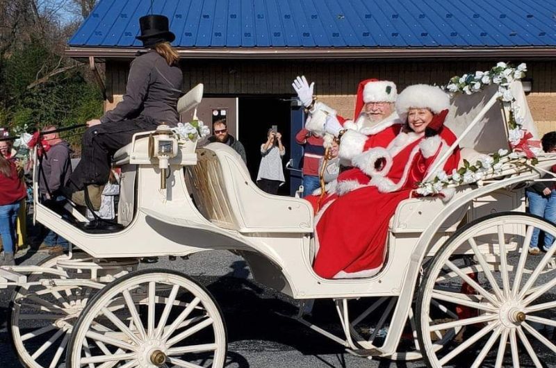 Dressed as Mrs. Claus, Helen Vopasek smiles and waves from a sleigh.