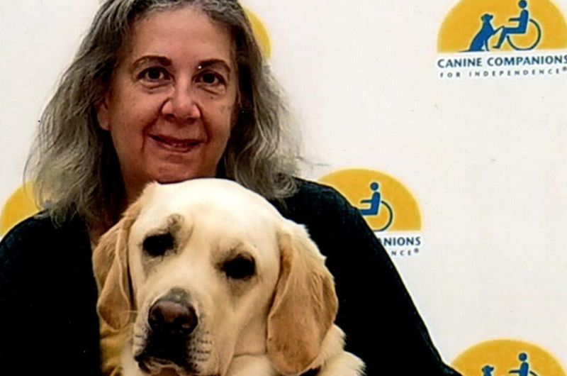 Cape Cod resident Dawn Laughlin poses for a picture with a support dog.