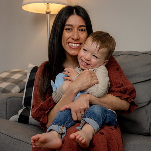 Image shows Hackensack Meridian Health Patient, Amanda Lee Davis, posing for a photo with her young son on the couch.
