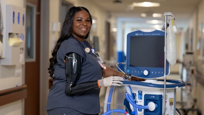 Ciera Coleman shows her prosthetic arm in a hospital hallway.