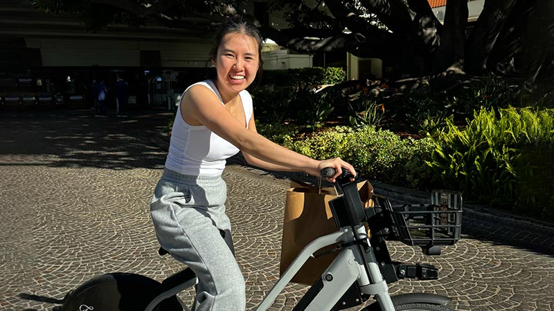 Tram Huynh of San Jose, California smiles while riding an e-bike.