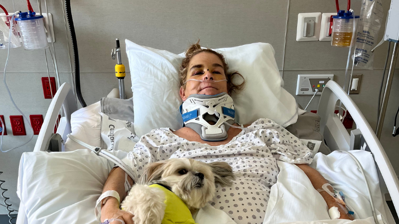 Professional horse trainer Jennifer R. smiles from a hospital bed.