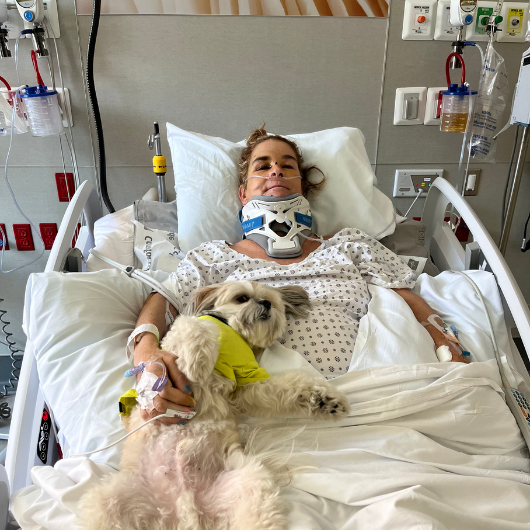 Professional horse trainer Jennifer R. smiles from a hospital bed.