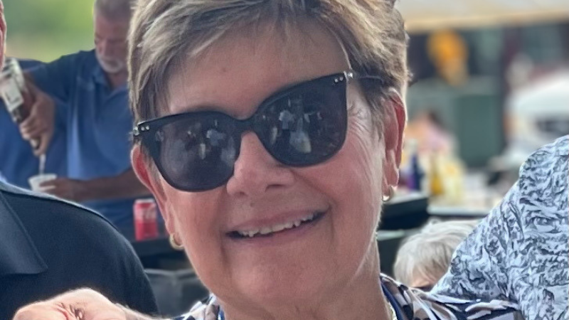 72-year-old, retired teacher Ruth Davitt smiles at the camera. 