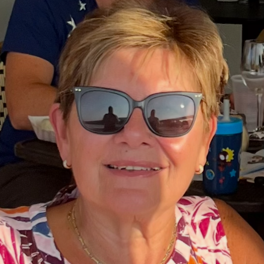 72-year-old, retired teacher Ruth Davitt smiles at the camera.