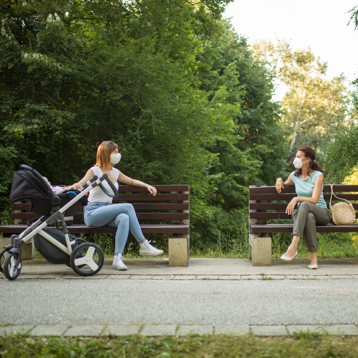 Two women outdoors talking with masks on