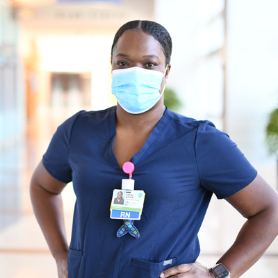 Nurse with hands on her hips and mask on