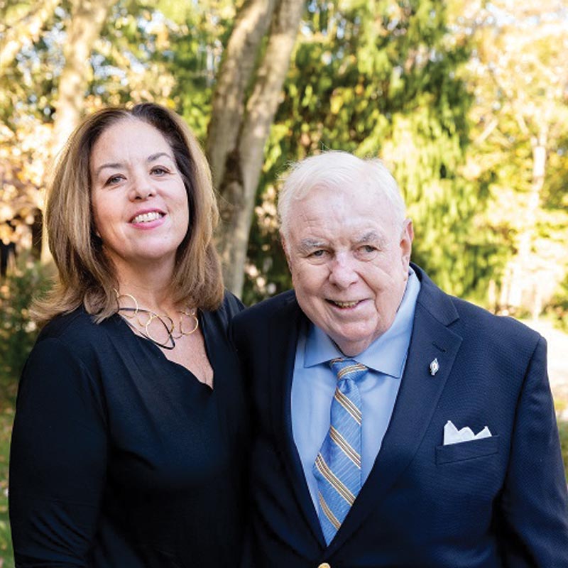 Women in black dress standing next to an elderly man