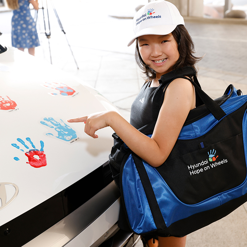 Young girl pointing to a handprint on a vehicle