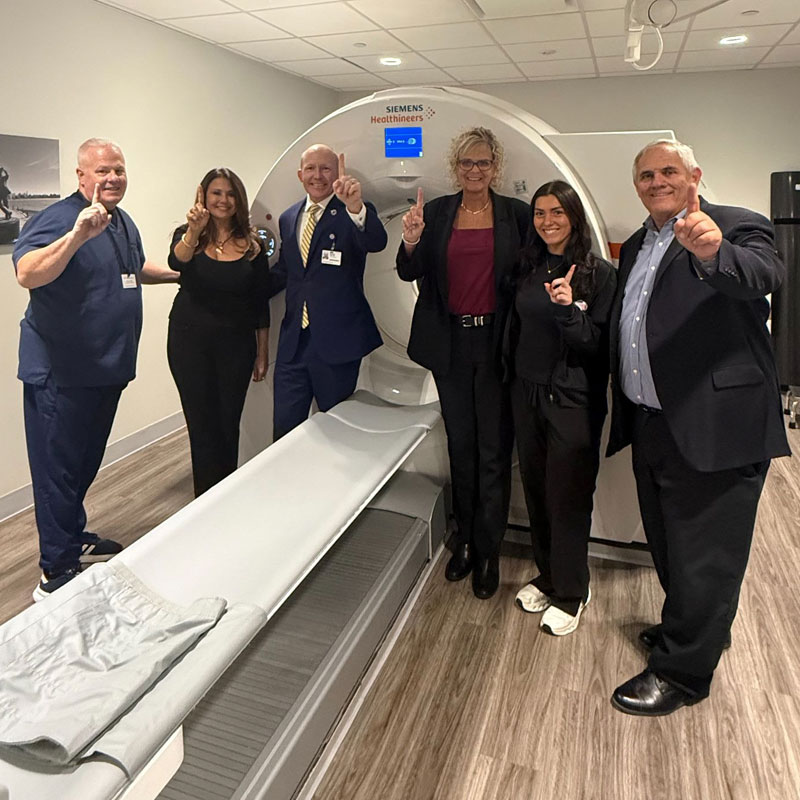 HMH leaders and physicians standing by imaging machine