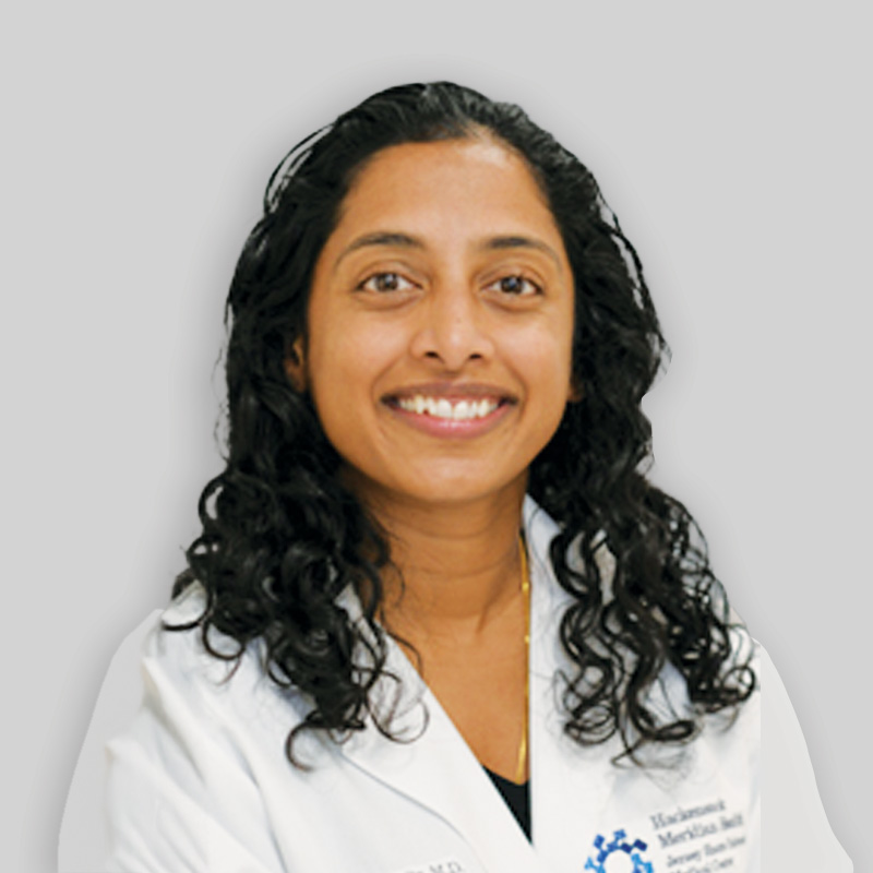 Women with curly brown hair wearing a white lab coat