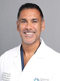 Man in white lab coat smiling