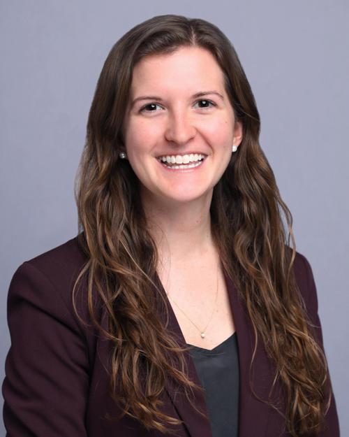 women with long brown hair smiling wearing a black blazer