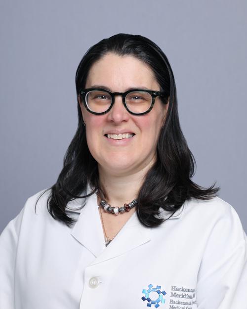 women with long black hair wearing glasses with a white lab coat