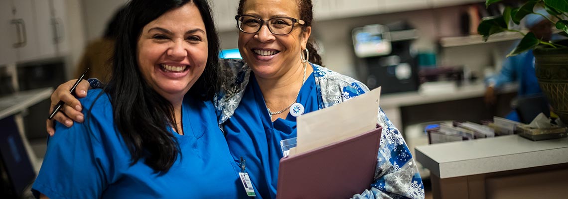 Two providers laughing together in a hospital