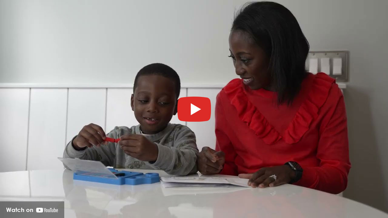 Woman and young boy sitting at a table working on an activity together