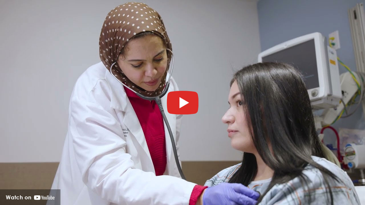 Physician listening to patient's chest with a stethoscope.