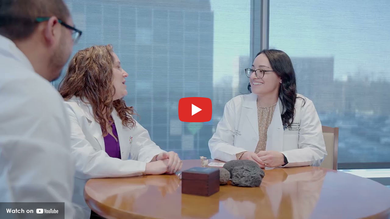 Three physicians having a conversation at a round table.