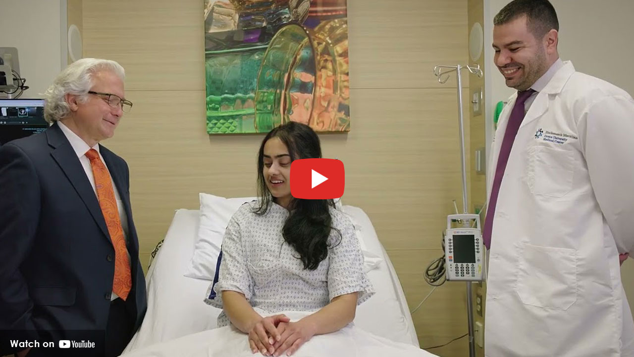 Two doctors standing around patient on bed