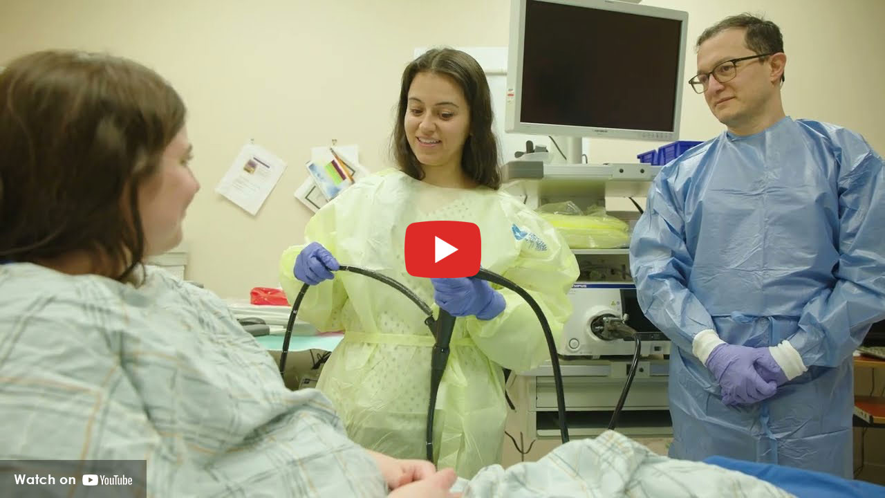 gastro doctors in scrubs talking to patient in hospital bed