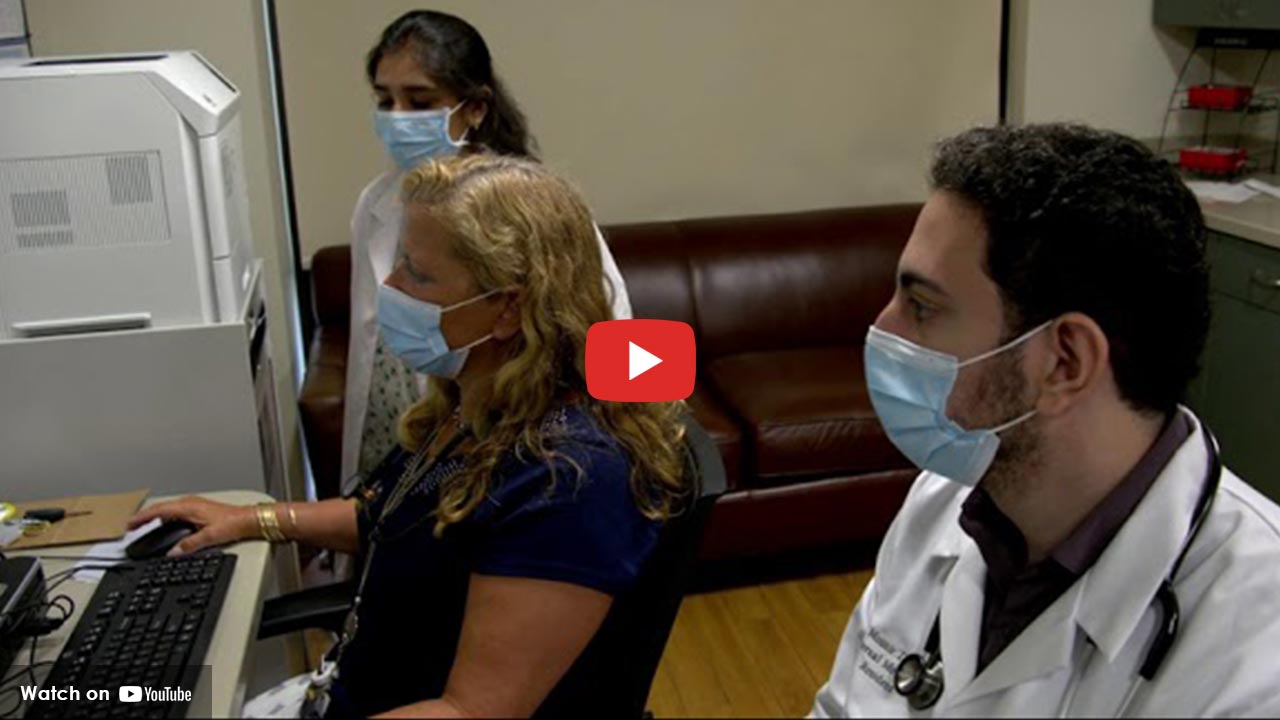 people wearing a mask sitting in front of a computer