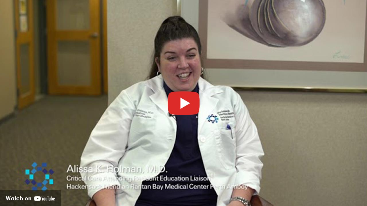 women in lab coat sitting down talking
