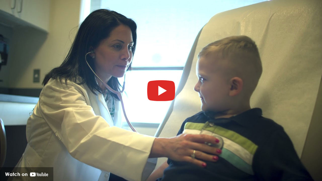 Doctor listening to a young boy’s heartbeat during a medical exam