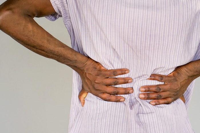 person clenching lower back from back pain