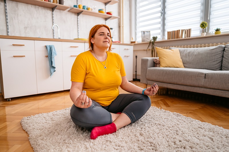 Young woman after weight loss surgery meditating and working out. 