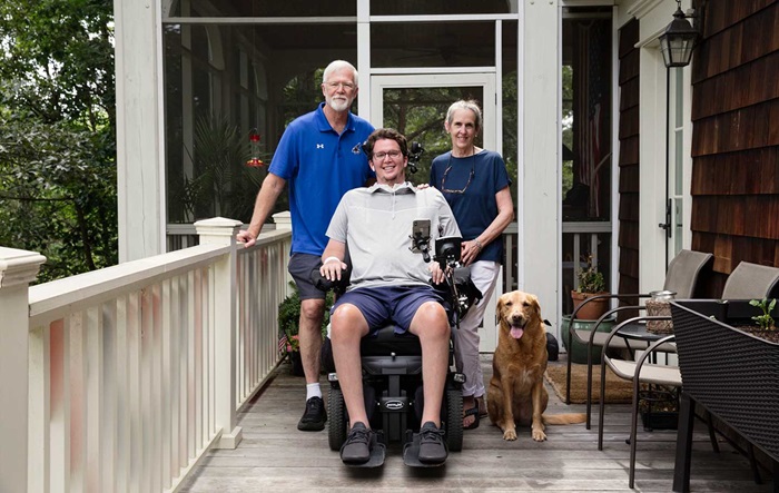 Parents and dog with adult son in wheelchair
