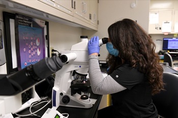 Girl In Lab Looking thru a Microscope