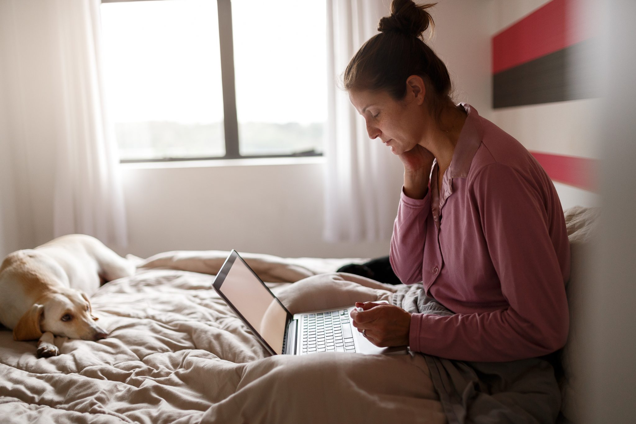 Woman in Bed at Telemedicine Appointment