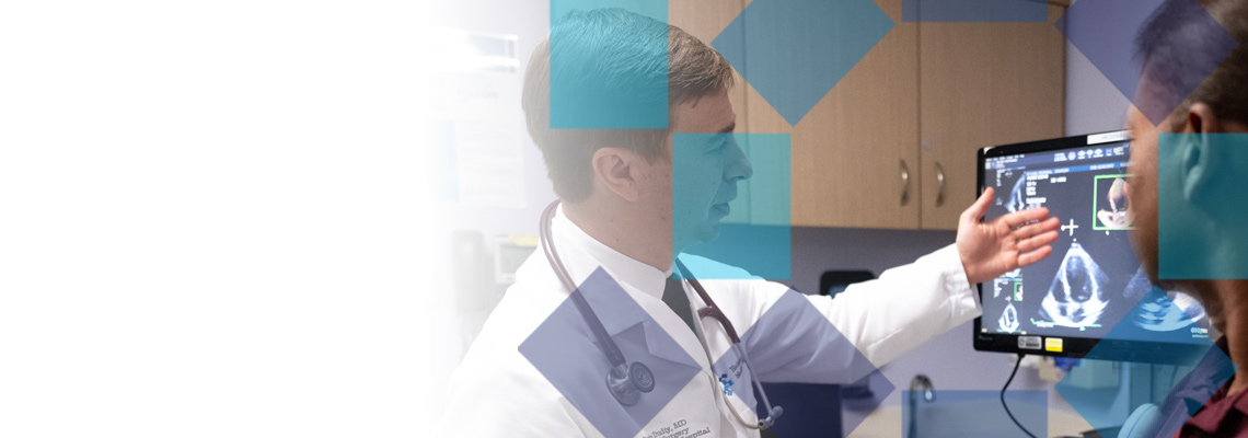 Doctor explaining echocardiogram results to a patient in a medical office