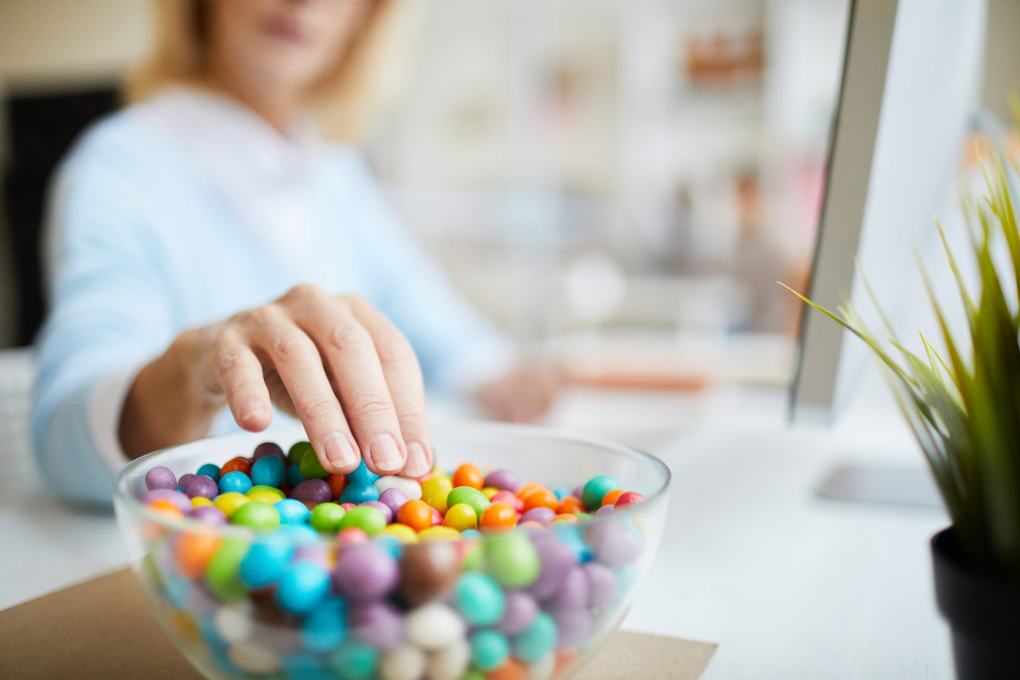 Person reaching for bowl of candy