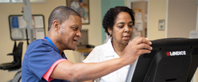 Physical therapist working with patient on treadmill