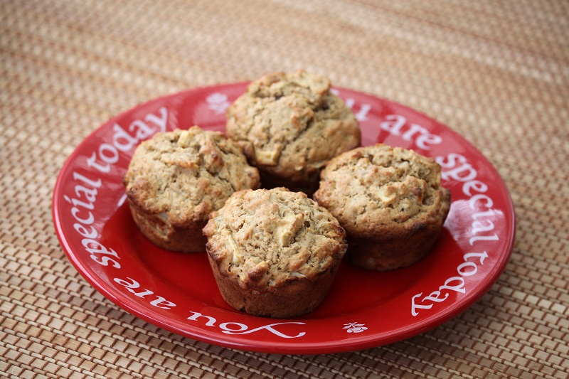 Applesauce walnut muffins on a red dish on a table. 