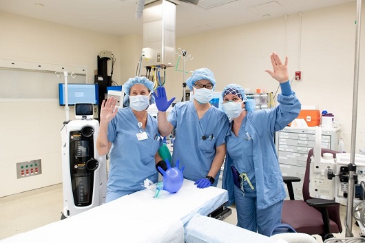 pediatric surgical team smiling and waving from the operating room