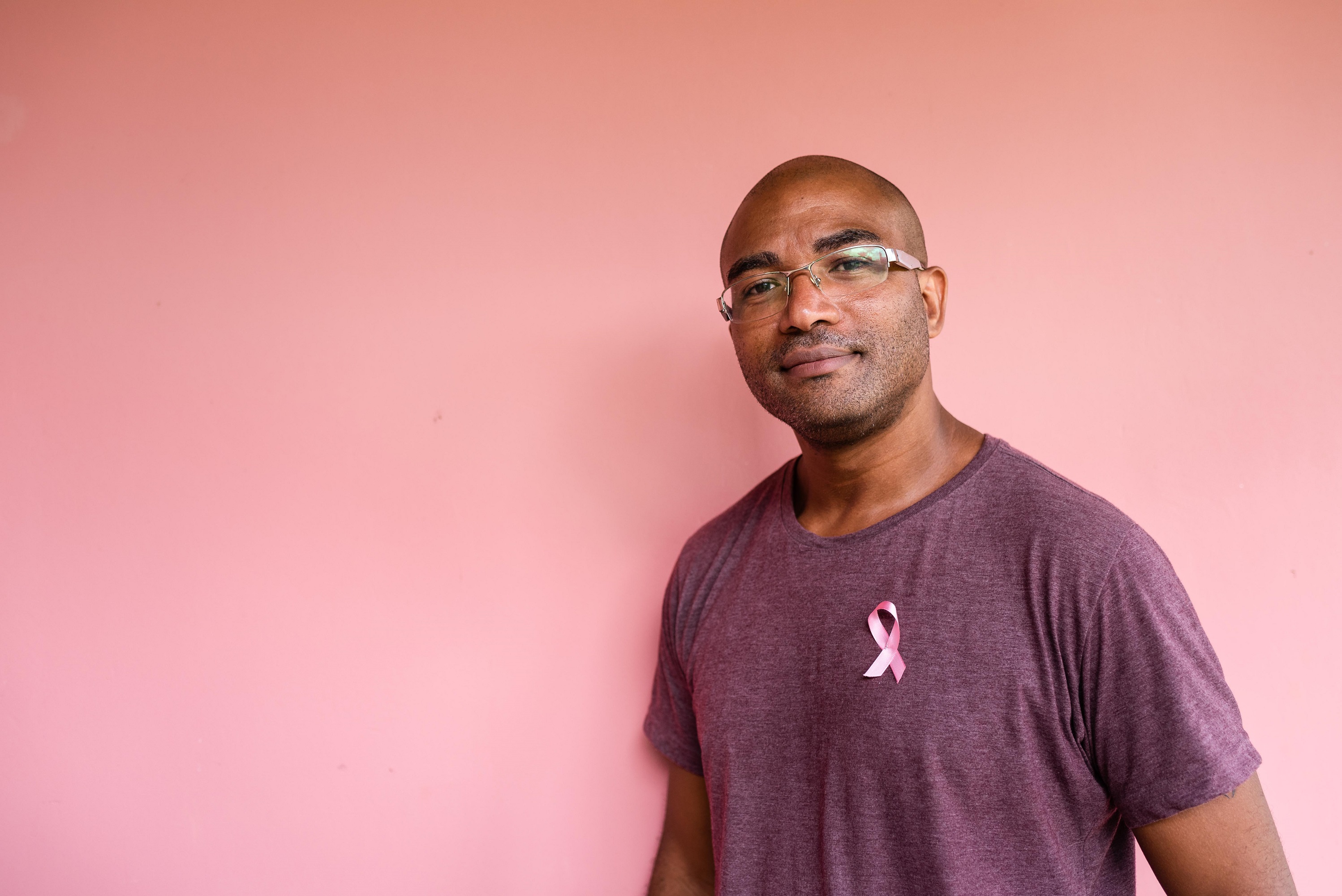 black male wearing a breast cancer awareness ribbon