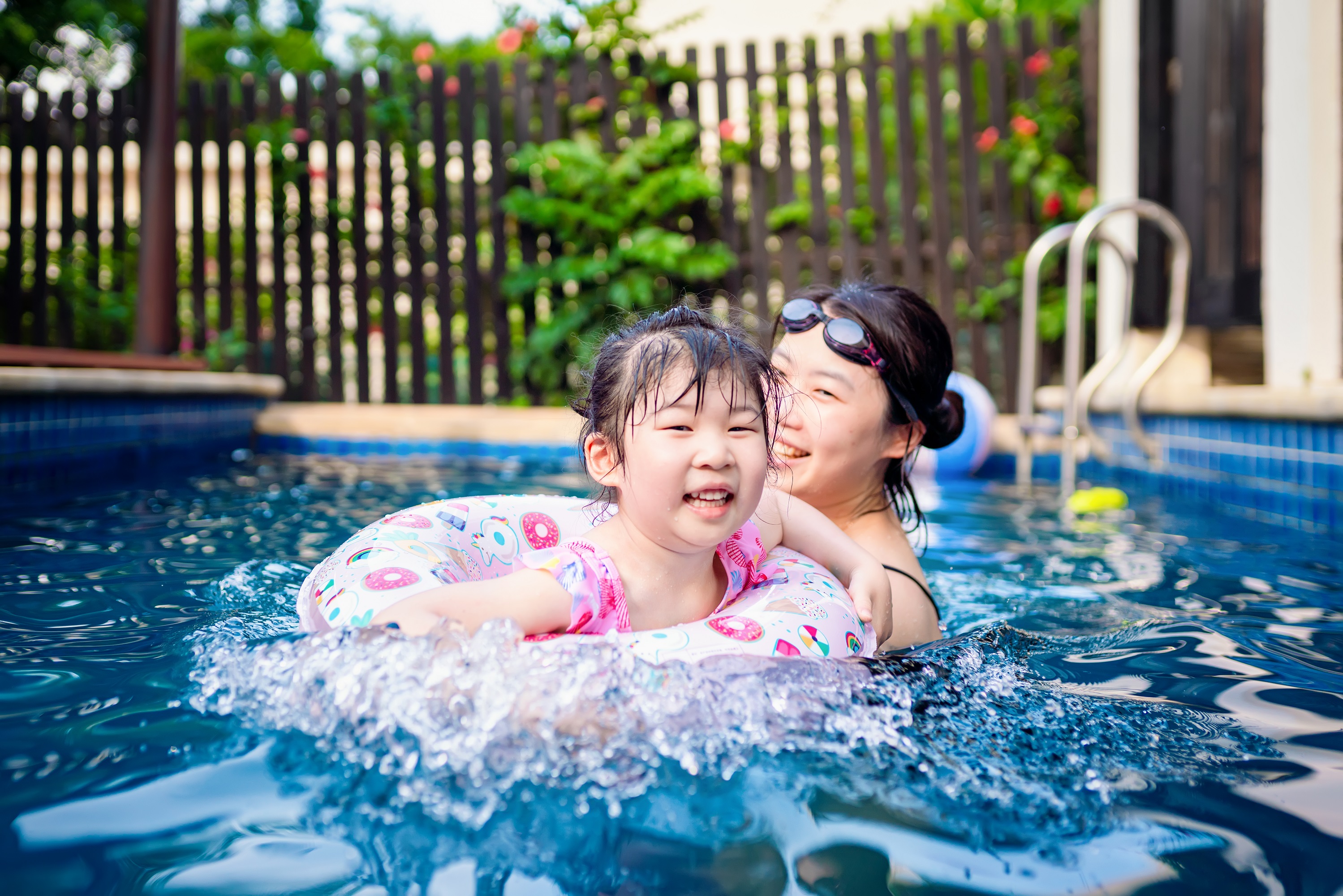 parent and child swimming in pool