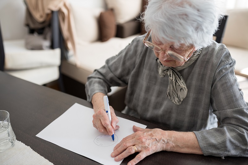 High angle view of a senior Caucasian woman doing Alzheimer's disease cognitive functions assessment test 