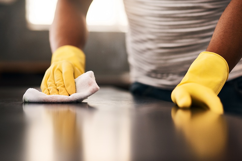 Close up of a counter being wiped down to clean off viruses, germs and
