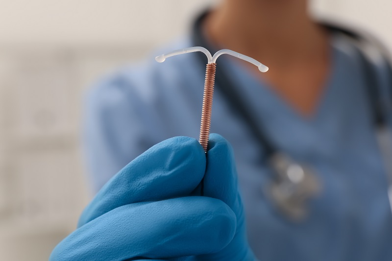Physician holding an IUD with gloves on. Pregnancy contraception. 