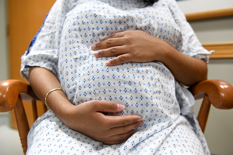 Pregnant mother holding her belly in the hospital before birth.