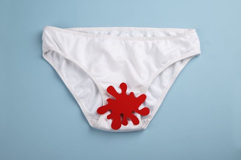 White underwear with a splatter of red, representing vaginal bleeding. Unexpected bleeding after sex.