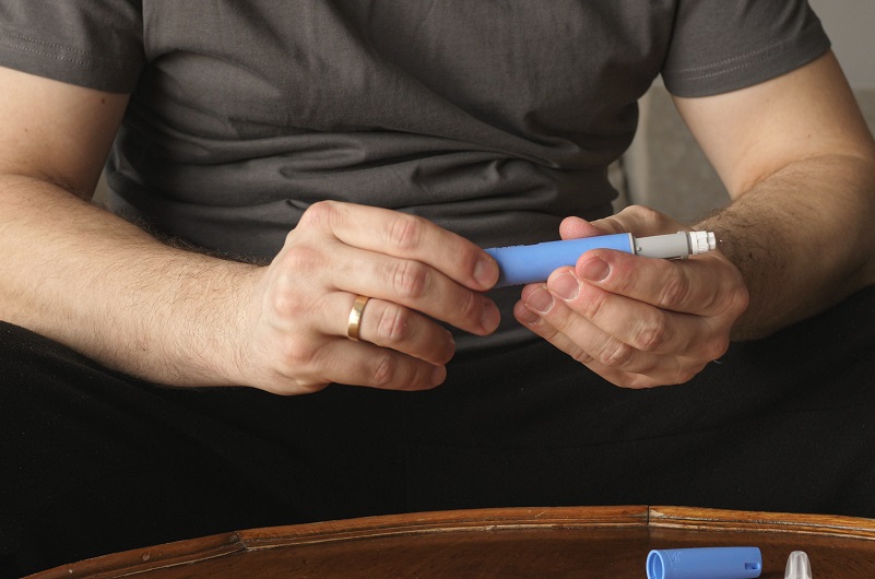 Man preparing Ozempic injection control blood sugar levels and obesity.