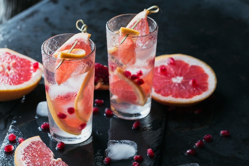 Grapefruit and pomegranate mocktail, refreshing summer drink with crushed ice and sparkling water