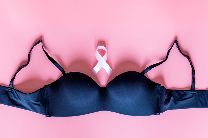 Flat lay top view of black female underwear with pink ribbon - symbol of breast cancer awareness