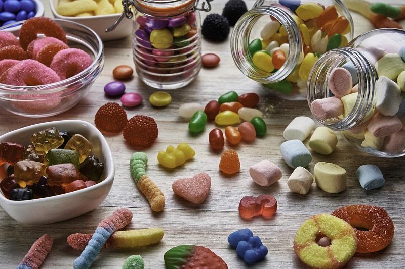 Close-up view of an assortment of colorful jellybeans, lollipops, candies and marshmallows.