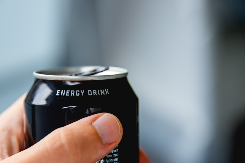 Closeup of a hand holding a can of energy drink.